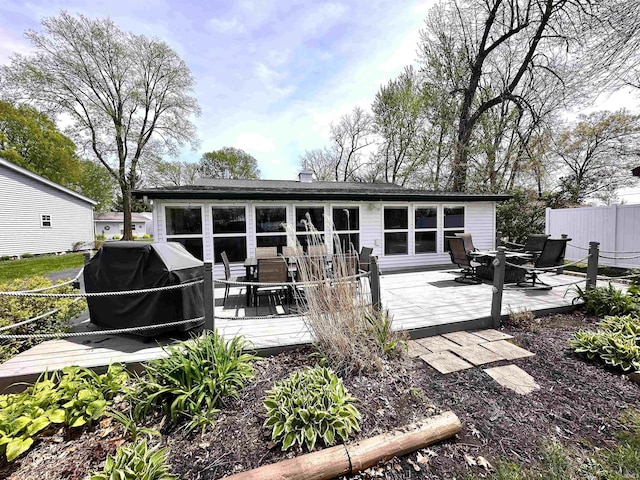 back of house featuring a wooden deck, fence, and outdoor dining space