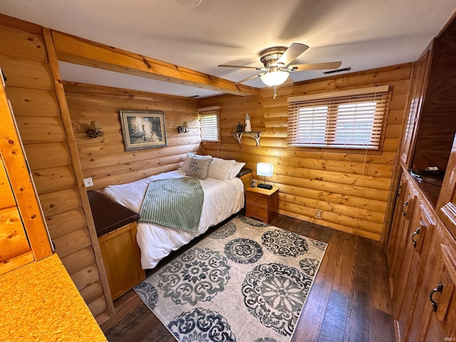 bedroom with log walls, dark wood finished floors, and beamed ceiling