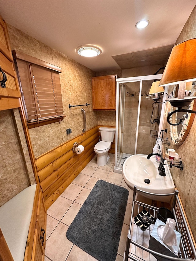 bathroom featuring a sink, tile patterned flooring, a shower stall, and toilet
