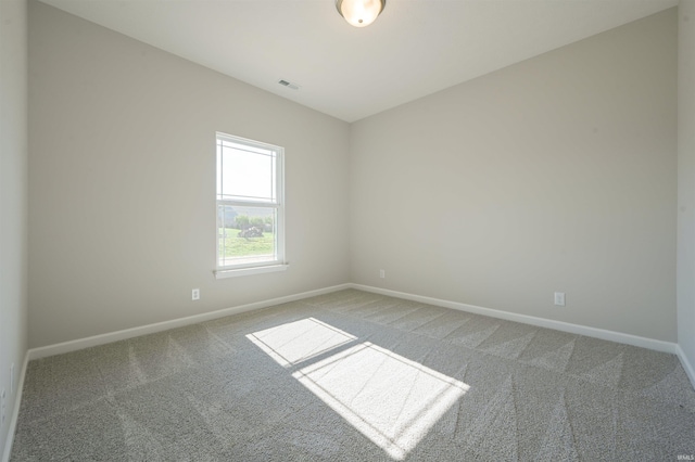 carpeted spare room featuring baseboards and visible vents