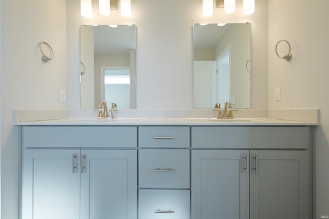 full bathroom with a sink and double vanity
