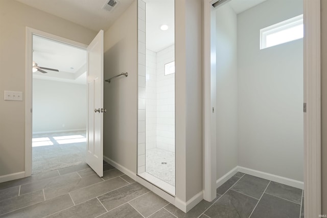 full bath featuring a ceiling fan, baseboards, visible vents, and tiled shower