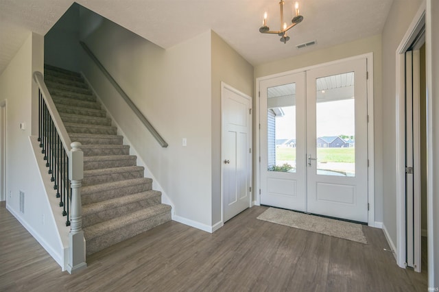 foyer entrance featuring french doors, visible vents, wood finished floors, stairway, and baseboards
