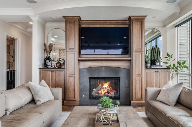 living area with recessed lighting, ornamental molding, light wood finished floors, and a fireplace