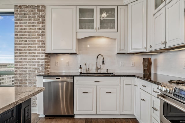 kitchen with a sink, white cabinetry, tasteful backsplash, and stainless steel appliances