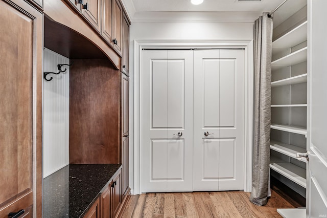 mudroom featuring ornamental molding and light wood-style flooring