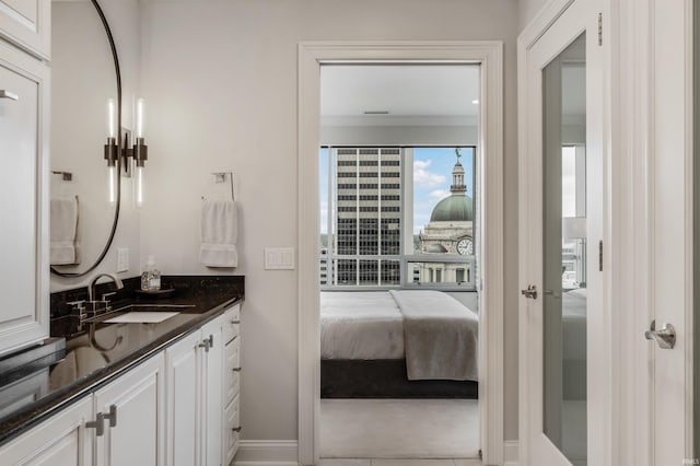 bathroom with vanity, baseboards, and ensuite bath