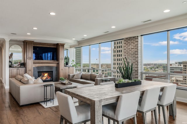 dining area featuring a fireplace, dark wood-type flooring, recessed lighting, and visible vents