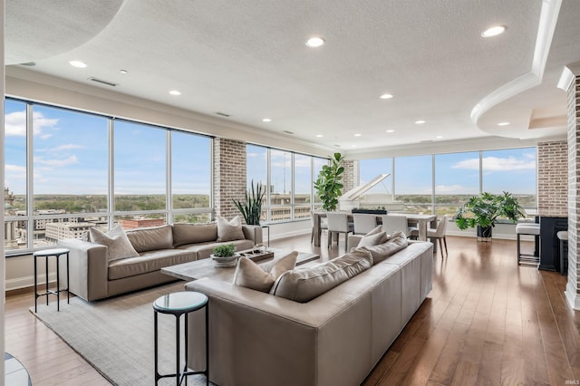 living room with wood-type flooring, recessed lighting, a textured ceiling, and visible vents