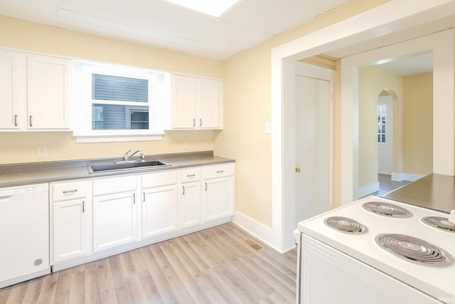 kitchen featuring a sink, arched walkways, white cabinets, and white appliances