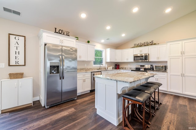 kitchen featuring visible vents, dark wood finished floors, appliances with stainless steel finishes, and a kitchen island