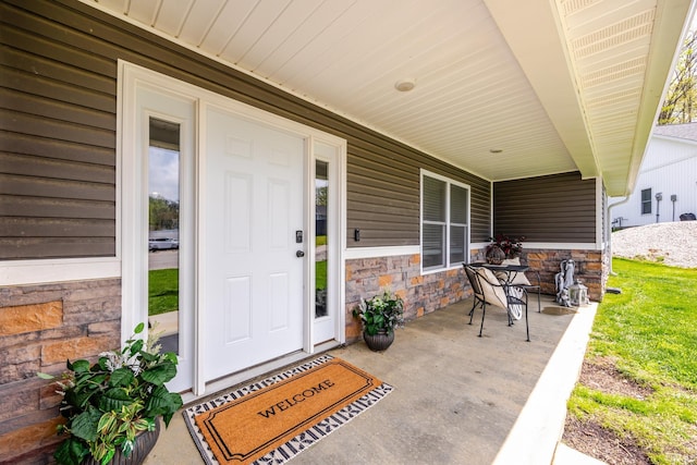 property entrance featuring covered porch and stone siding