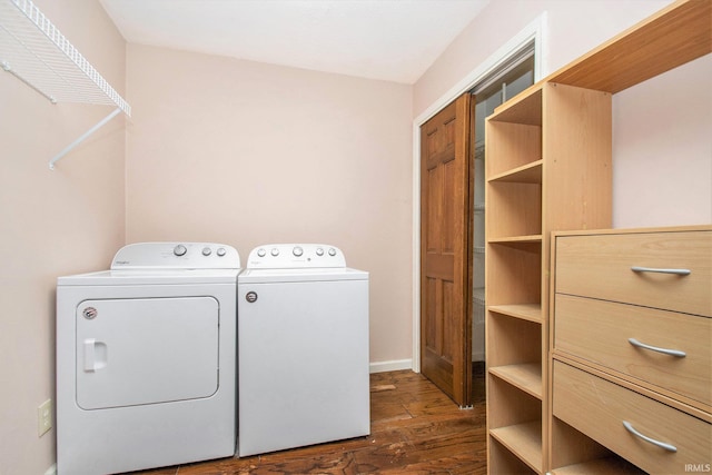 laundry room with laundry area, washing machine and dryer, baseboards, and dark wood-type flooring