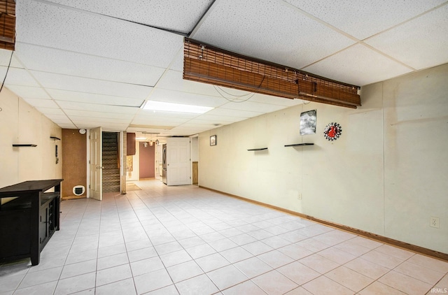 finished below grade area with stairs, baseboards, and a drop ceiling