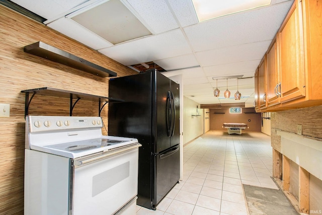 kitchen featuring brown cabinets, white range with electric cooktop, a paneled ceiling, freestanding refrigerator, and light tile patterned floors