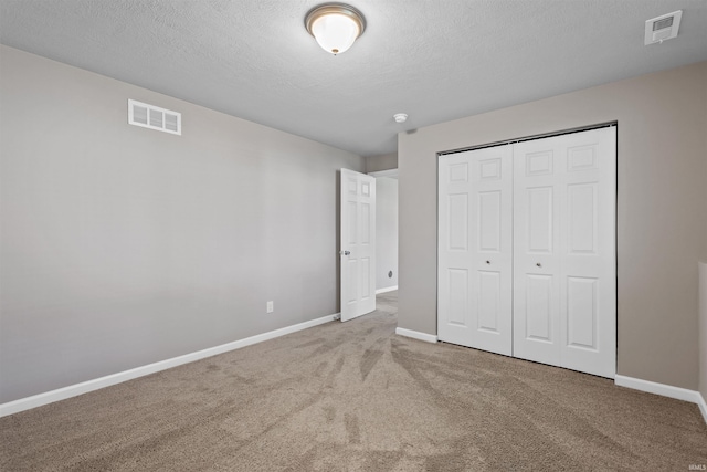 51779 Hannigan Dr, South Bend, IN 46637 - unfurnished bedroom with carpet flooring, baseboards, a closet, and a textured ceiling