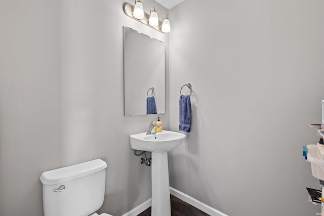 51779 Hannigan Dr, South Bend, IN 46637 - bathroom featuring toilet, baseboards, a sink, and wood finished floors