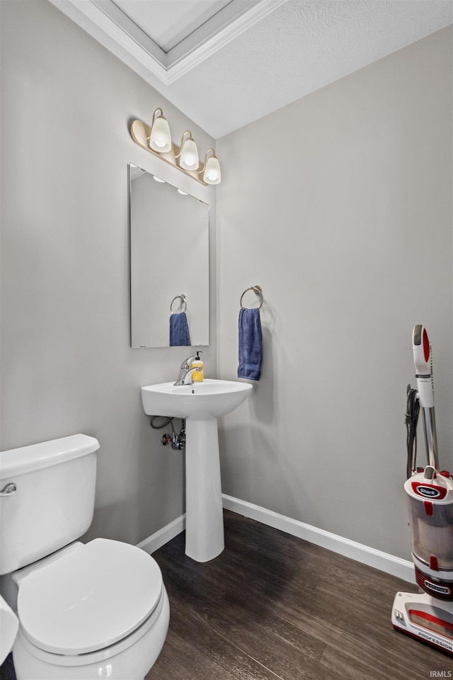 51779 Hannigan Dr, South Bend, IN 46637 - bathroom featuring wood finished floors, baseboards, toilet, and a sink