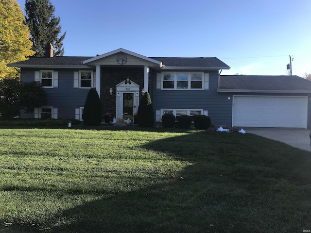 bi-level home featuring concrete driveway, an attached garage, a chimney, and a front yard