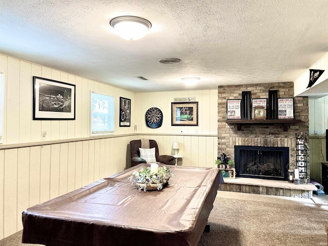 living area featuring a textured ceiling, carpet, and a fireplace