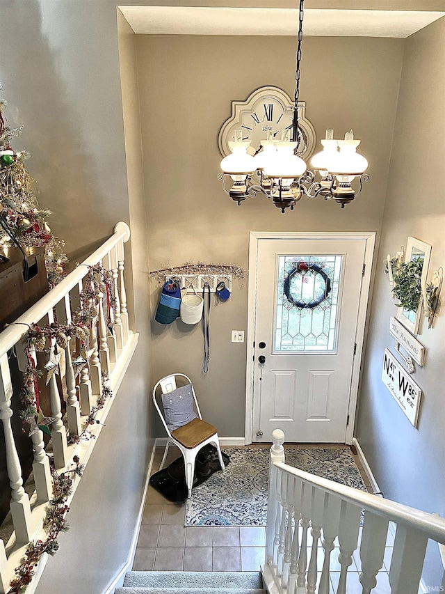 entrance foyer featuring baseboards, tile patterned flooring, and a notable chandelier