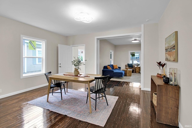 dining area with baseboards and dark wood finished floors