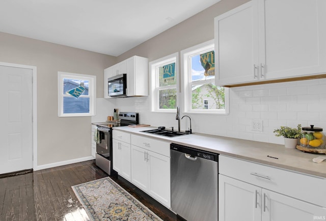 kitchen with a sink, dark wood finished floors, appliances with stainless steel finishes, and tasteful backsplash