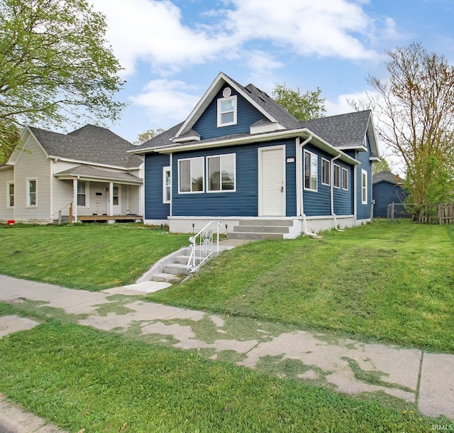 bungalow with a shingled roof and a front lawn