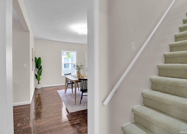 staircase with baseboards and wood finished floors
