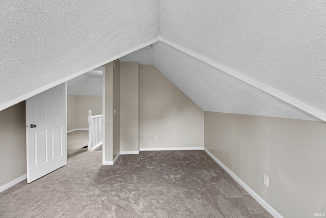bonus room with baseboards, carpet, a textured ceiling, and vaulted ceiling