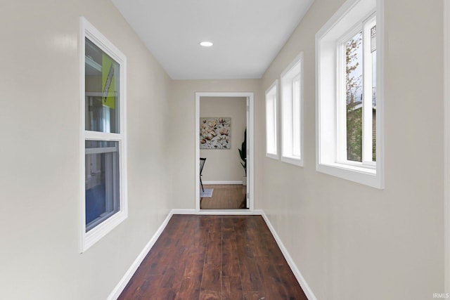 corridor with baseboards, recessed lighting, and dark wood finished floors