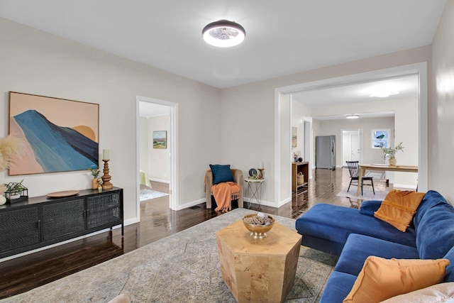living area with baseboards and wood finished floors