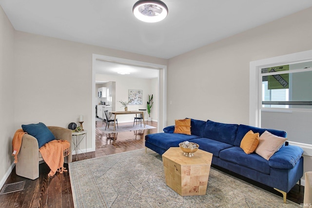 living room featuring baseboards, wood finished floors, and visible vents