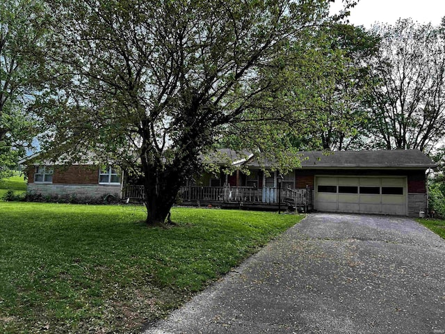 view of front of home with an attached garage, a front yard, stone siding, and aphalt driveway