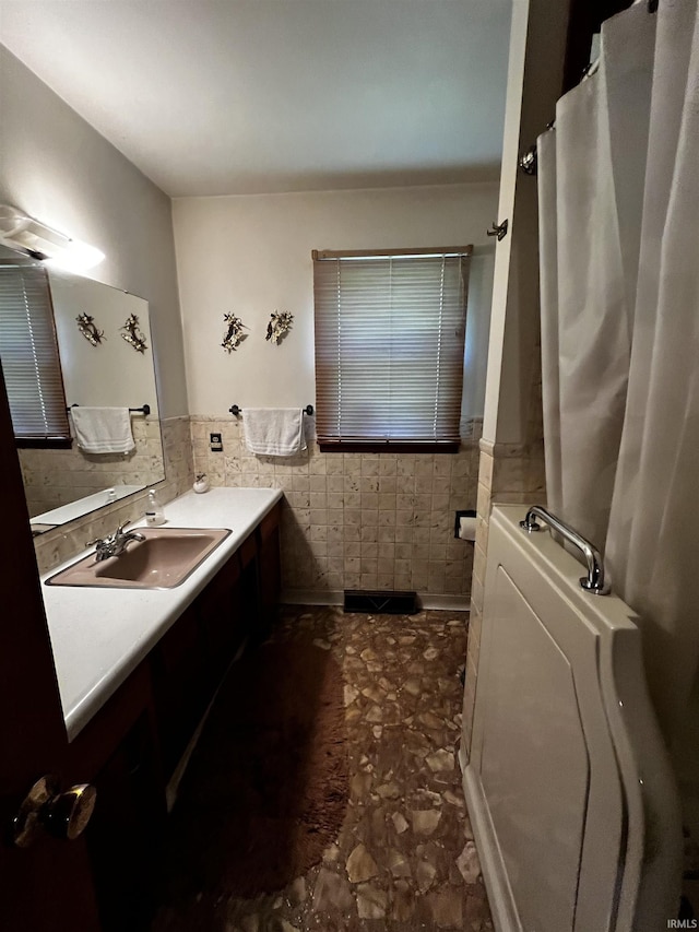 607 Troy Rd, Washington, IN 47501 - full bathroom featuring vanity, tile walls, a shower with shower curtain, and a wainscoted wall