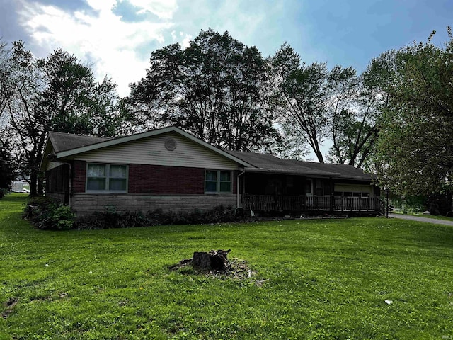 view of front of property featuring covered porch, a garage, and a front lawn
