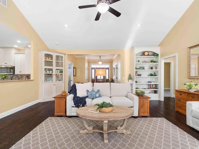 living area featuring baseboards, a ceiling fan, wood finished floors, and vaulted ceiling