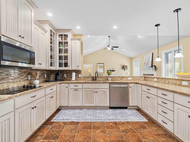 kitchen featuring glass insert cabinets, ceiling fan, a sink, backsplash, and stainless steel appliances