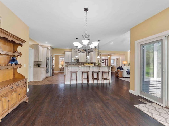 interior space with baseboards, recessed lighting, a notable chandelier, and dark wood-style floors