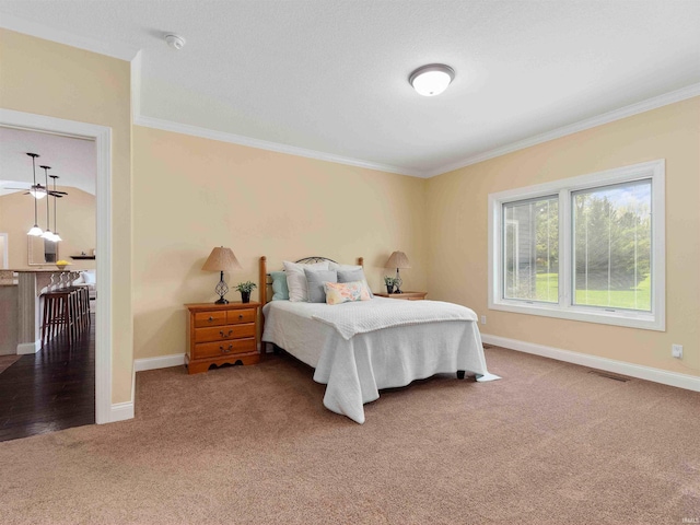 bedroom with crown molding, carpet flooring, and baseboards