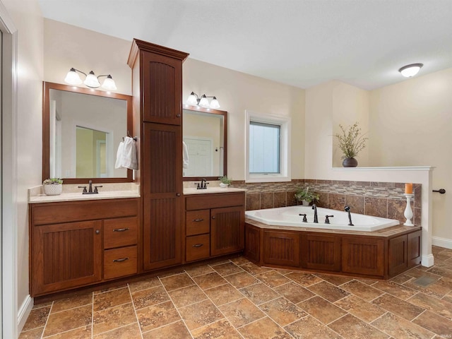 full bath featuring double vanity, a sink, a bath, and stone finish floor