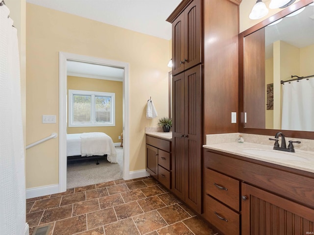 bathroom featuring visible vents, vanity, baseboards, connected bathroom, and stone finish flooring