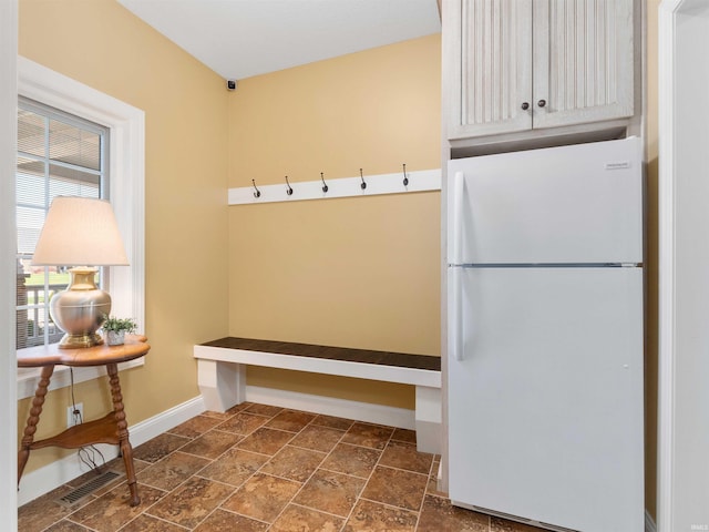 mudroom featuring baseboards, stone tile flooring, and visible vents