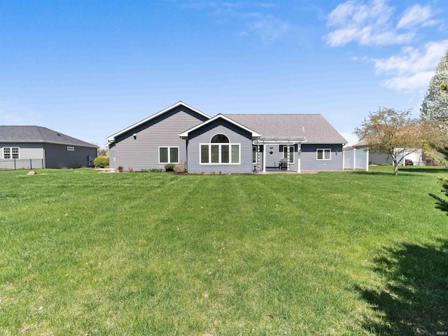rear view of house featuring a lawn, fence, and a pergola