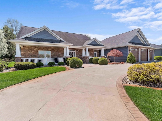 view of front facade with curved driveway, brick siding, covered porch, and a front yard
