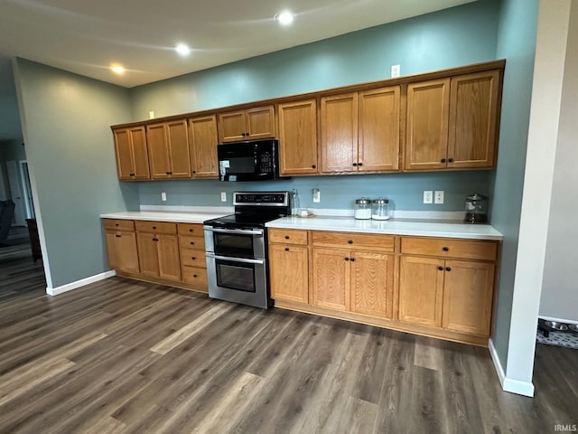 8679 E 850th St, New Carlisle, IN 46552 - kitchen featuring brown cabinets, range with two ovens, black microwave, and dark wood finished floors