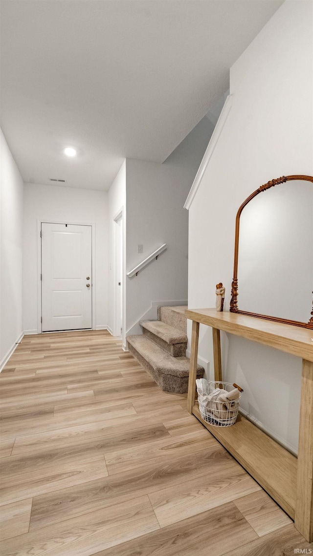 corridor with recessed lighting, baseboards, wood finished floors, and stairway