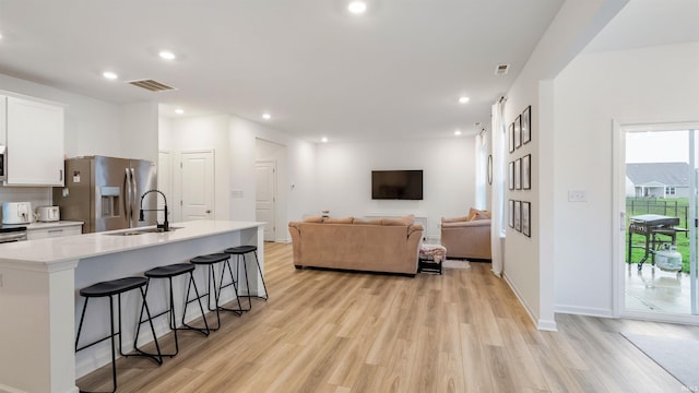 living area featuring visible vents, recessed lighting, and light wood-style floors