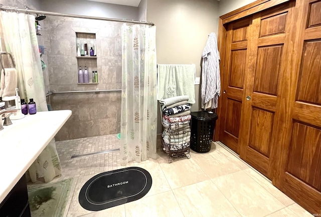 bathroom with tile patterned flooring and a tile shower