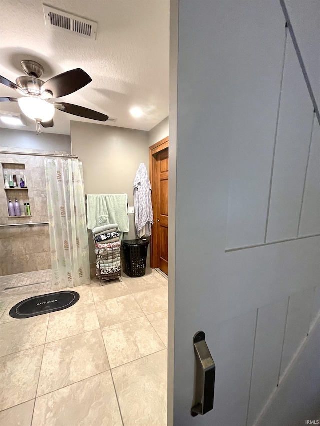bathroom featuring a shower with curtain, ceiling fan, a textured ceiling, visible vents, and tile patterned floors